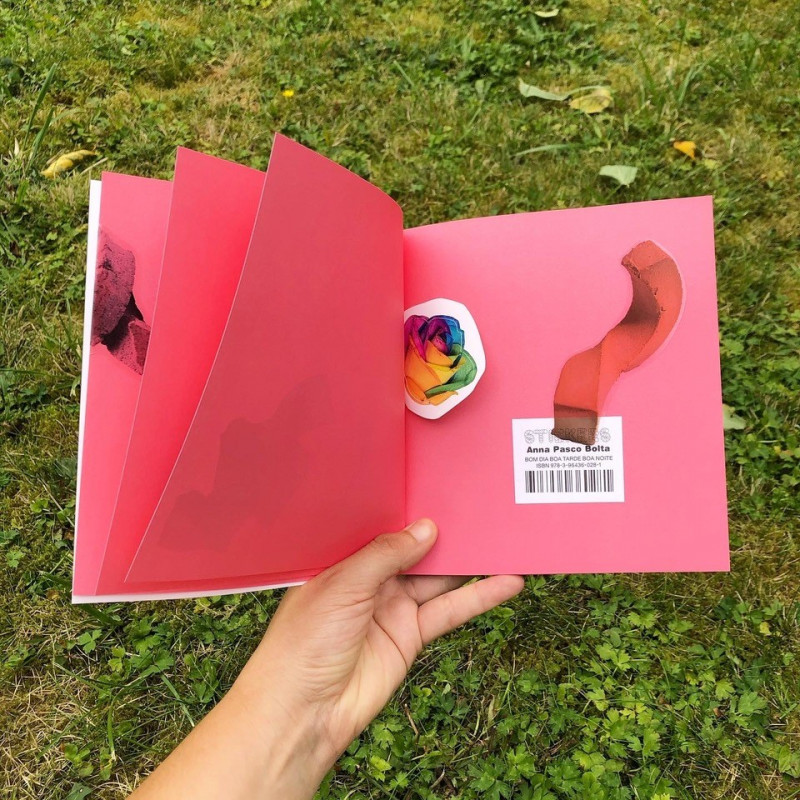Hand hält geöffnetes Stickeralbum mit Aufklebern, die Kunstgegenstände aus der Ausstellung abbilnden