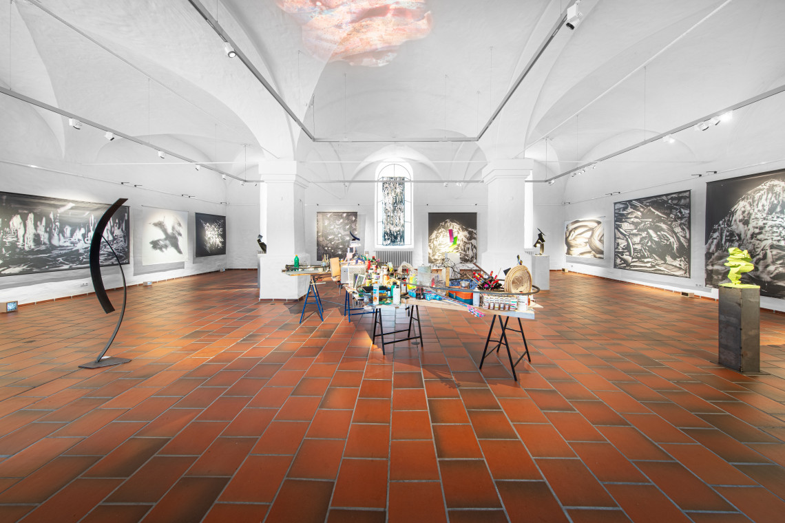 Installation in der Raummitte, großfächige Schwarz-Weiß-Bilder an den Wänden