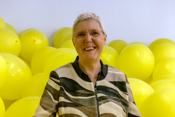 Dr. Mechthild M&uuml;ller-Hennig in einem Raum voller gelber Luftballons